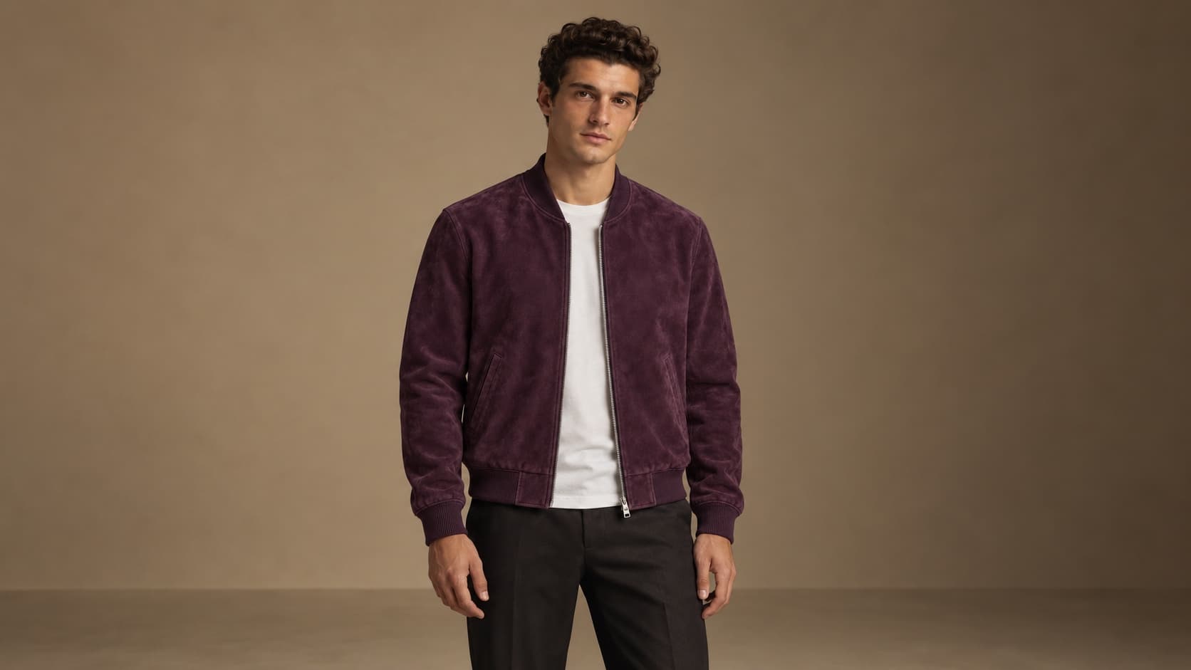 The same AI-generated model wearing the purple suede bomber jacket in a warm studio
